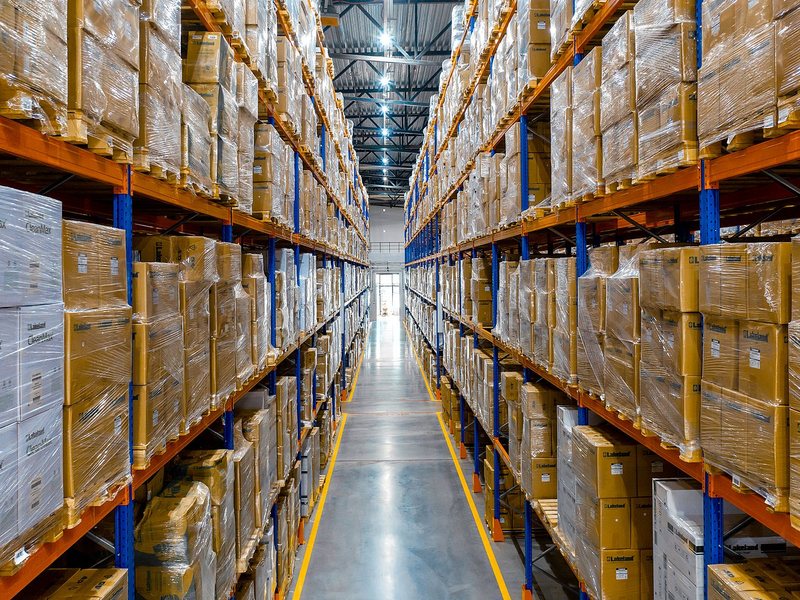 A long aisle between pallet racking in a BIOCARD Group pharmaceutical warehouse